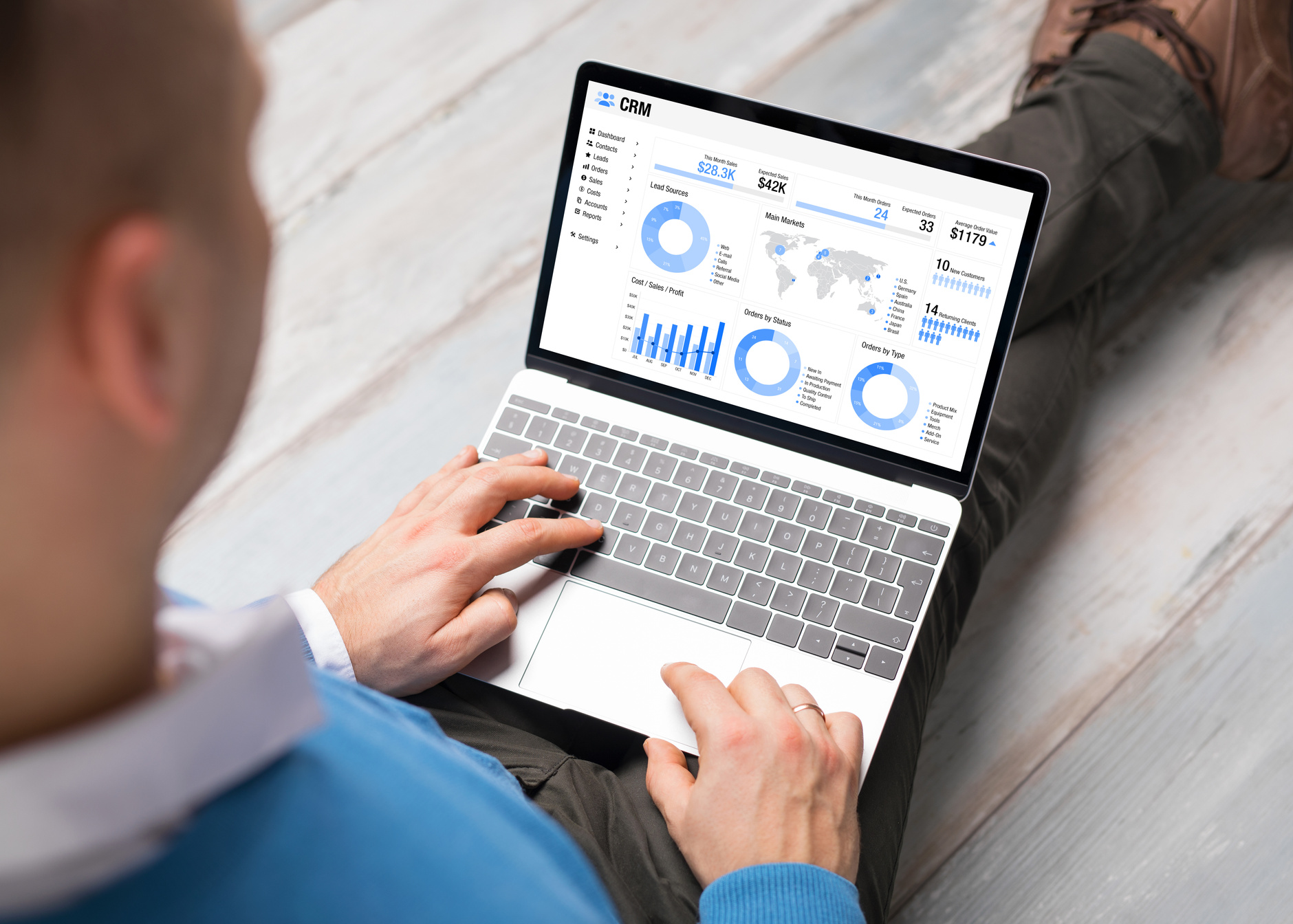 Man using CRM software on laptop with different graphs and charts showing sales data for his business